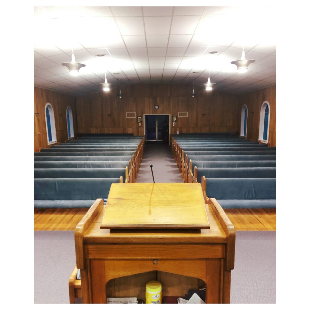 Perspective from empty Preacher's stand looking at empty church pews at Woodrow Baptist Church