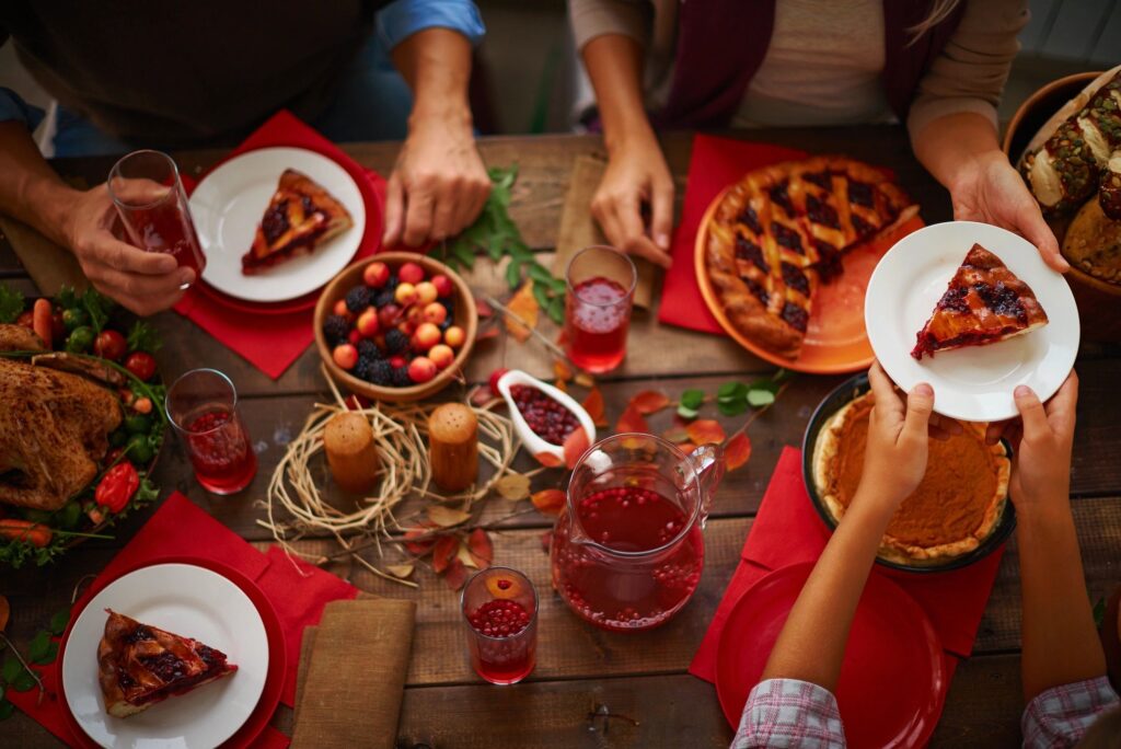 aerial view of people's hands gathered around a table eating pie